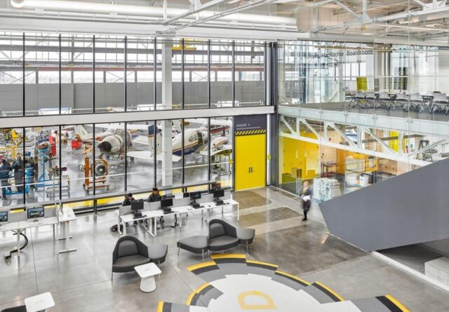 Inside a office with high ceilings and floor-to-ceiling windows.