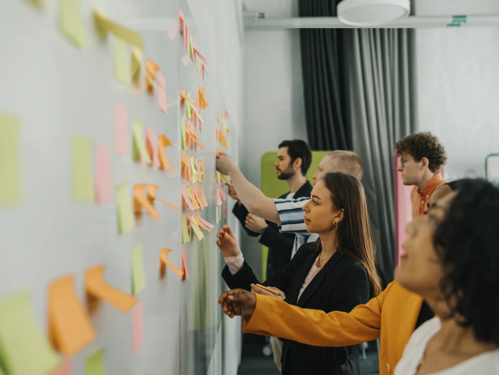 Group of people looking at a wall covered in sticky notes