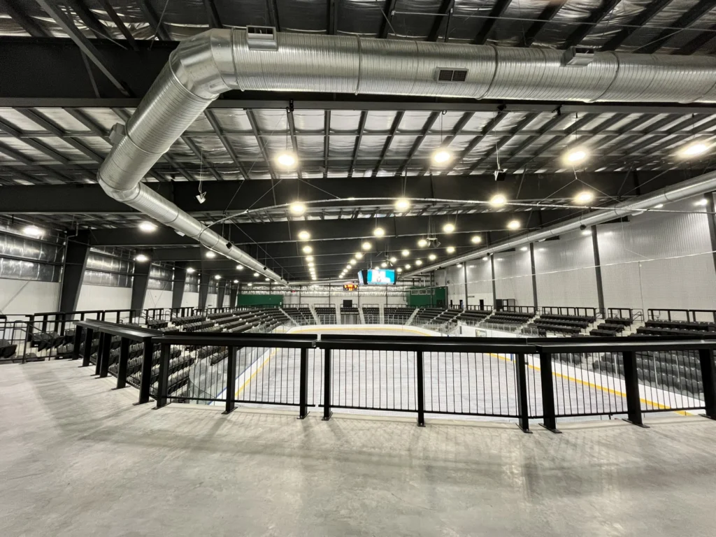 Inside look of a hockey rink, with smooth ice behind a black elevated gate