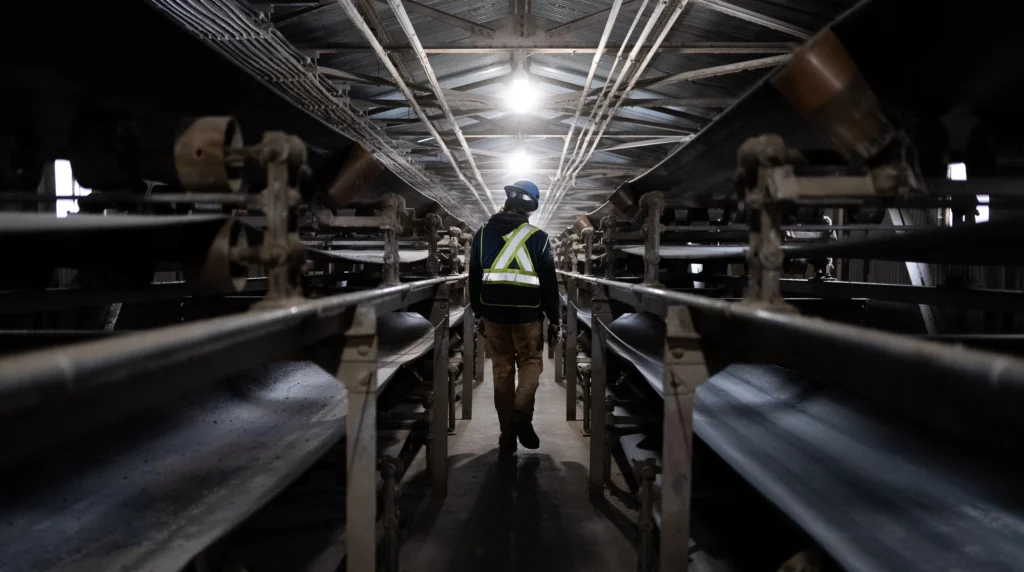 man walking between two industrial locomotive engines